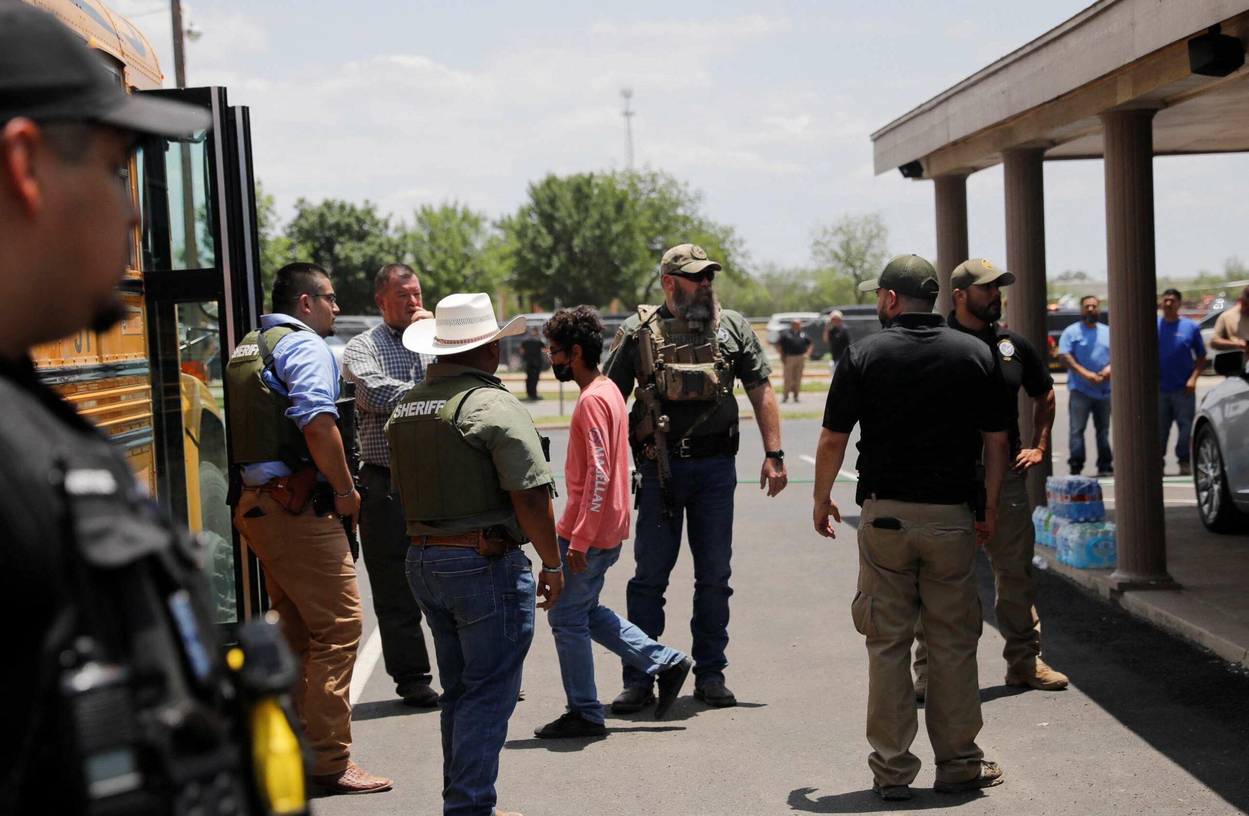Children on a school bus as law enforcement personnel secure the area around Robb Elementary School in Uvalde, Texas, where a shooting is suspected to have occurred.